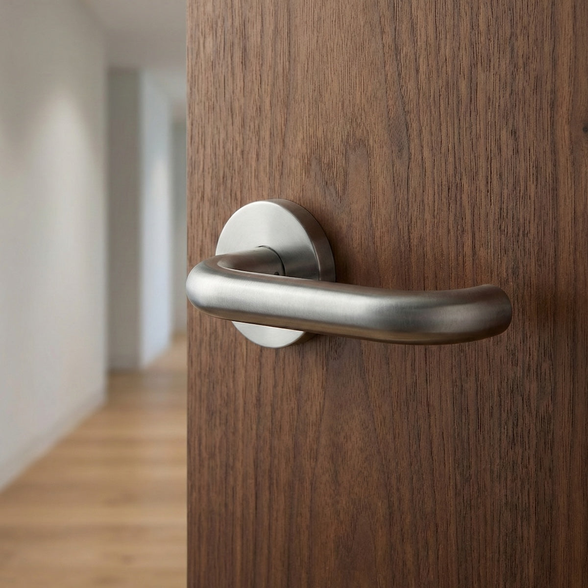 Lyr curved lever handle with round stainless steel rose for doors